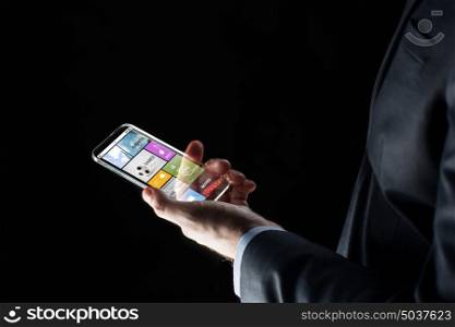 business, multimedia, people and future technology concept - close up of businessman hand with transparent smartphone with applications over black background. close up of businessman with apps on smartphone