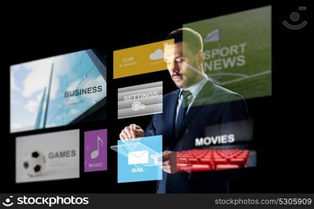 business, multimedia, people and technology concept - businessman in suit working with transparent tablet pc computer over black background. businessman with tablet pc and multimedia