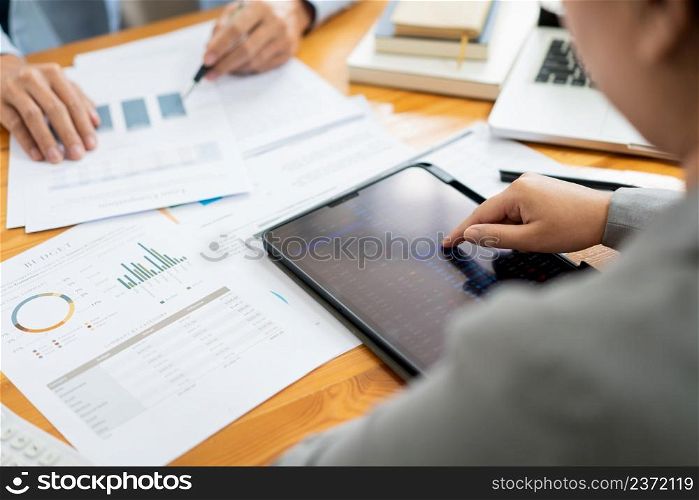 Business negotiation concept the businessman using the tablet to look into the detail of the real estate trends.