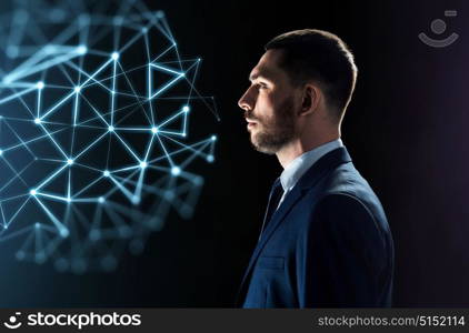 business, network, people and technology concept - businessman in suit looking at virtual low poly projection over black background. businessman looking at network virtual projection