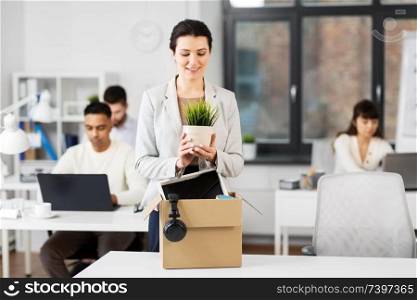 business, new job and corporate concept - happy smiling businesswoman with her personal stuff at office. happy businesswoman with personal stuff at office