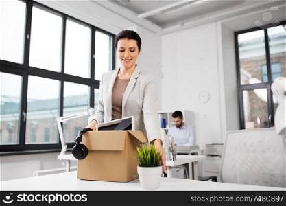 business, new job and corporate concept - happy smiling businesswoman with her personal stuff at office. happy businesswoman with personal stuff at office