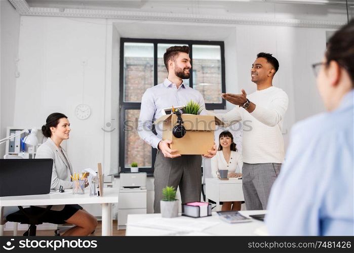 business, new job and corporate concept - male employee with personal stuff meeting colleagues at office. new male employee meeting colleagues at office