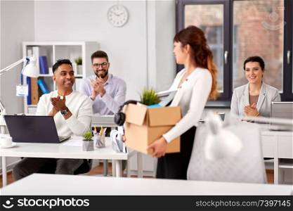 business, new job and quit concept - happy smiling colleagues applauding to female office worker holding her personal stuff. colleagues applauding to new female office worker
