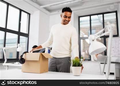business, new job and quit concept - happy smiling indian male office worker with personal stuff. happy male office worker with personal stuff