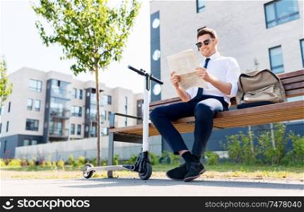 business news and corporate people and concept - young businessman with bag, electric scooter reading newspaper on street bench in city. businessman with scooter reading newspaper in city