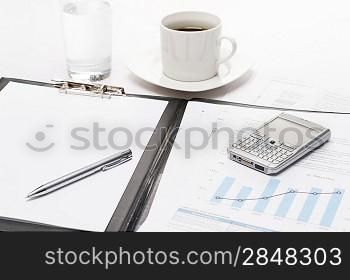 Business notepad phone and cup of coffee on office desk