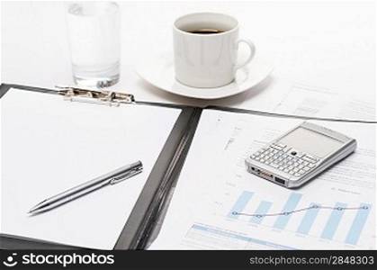 Business notepad phone and cup of coffee on office desk