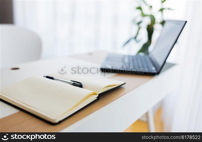 business, objects and education concept - close up of notebook and laptop computer on office table