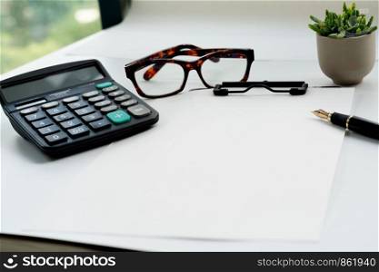 Business objects, clipboard with blank sheet of paper, pen, glasses and calculator on white background