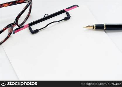 Business objects, clipboard with blank sheet of paper, pen, glasses on white background