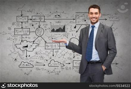 business, office, advertising and people concept - friendly young buisnessman showing big plan on concere wall