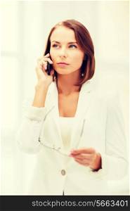 business, office and communication concept - businesswoman with smartphone in office