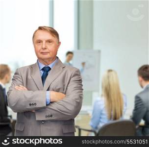 business, office and education concept - serious buisnessman or teacher in suit at office