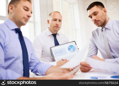 business, office and people concept - serious businessmen with papers in office