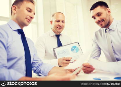 business, office and people concept - smiling businessmen with papers in office