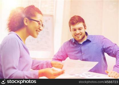 business, office and startup concep - smiling creative team with papers working in office
