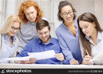 business, office and startup concep - smiling creative team with papers working in office