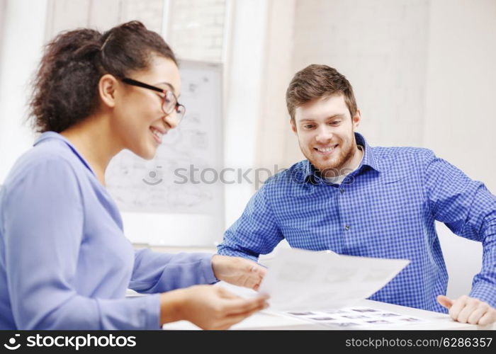 business, office and startup concep - smiling creative team with papers working in office