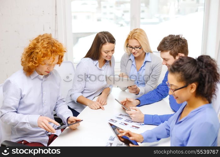 business, office and startup concep - smiling creative team with table pc computers and papers working in office