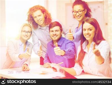 business, office and startup concept - creative team with papers and clipboard showing thumbs up