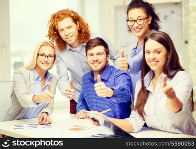 business, office and startup concept - creative team with papers and clipboard showing thumbs up