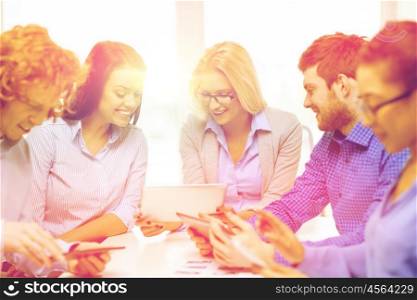 business, office and startup concept - smiling creative team with table pc computers and papers working in office