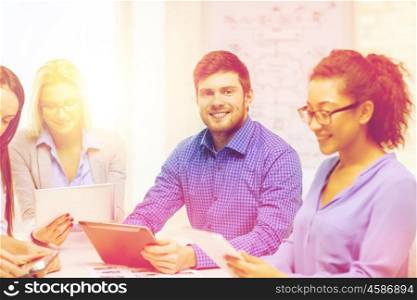 business, office and startup concept - smiling creative team with table pc computers and papers working in office