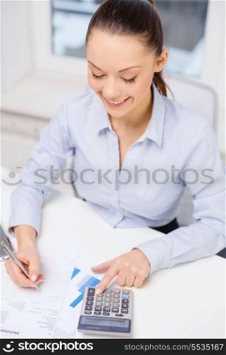 business, office and tax concept - smiling businesswoman working with documents in office
