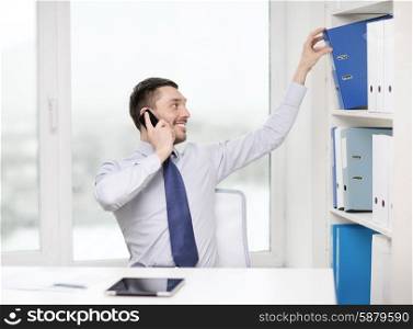 business, office and technology concept - smiling businessman with smartphone and tablet pc at office