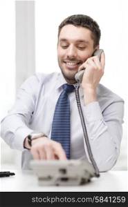 business, office and technology concept - smiling businessman with telephone dialing number at office