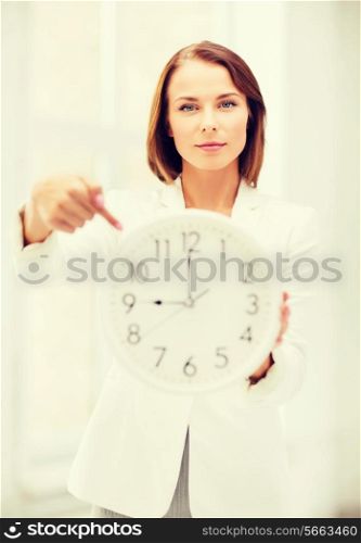 business, office and time management concept - attractive businesswoman with clock