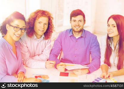 business, office, architecture and startup concept - smiling creative team with color samples and blueprint at office