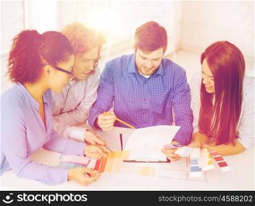 business, office, architecture and startup concept - smiling creative team with color samples and blueprint at office