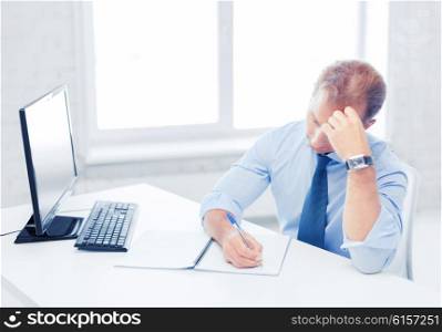 business, office, education and school concept - stressed businessman with notebook and computer