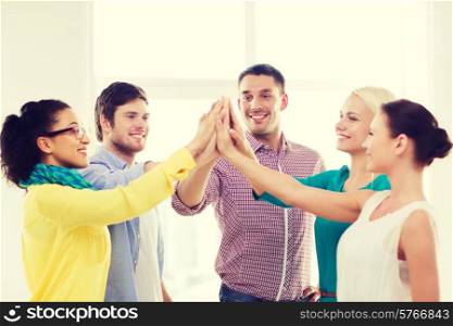 business, office, gesture and startup concept - smiling creative team doing high five gesture in office