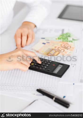business, office, household, school, tax and education concept - woman hand with calculator and euro money