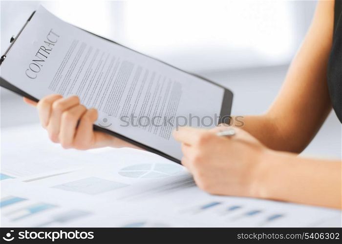 business, office, law and legal concept - picture of woman hand signing contract paper