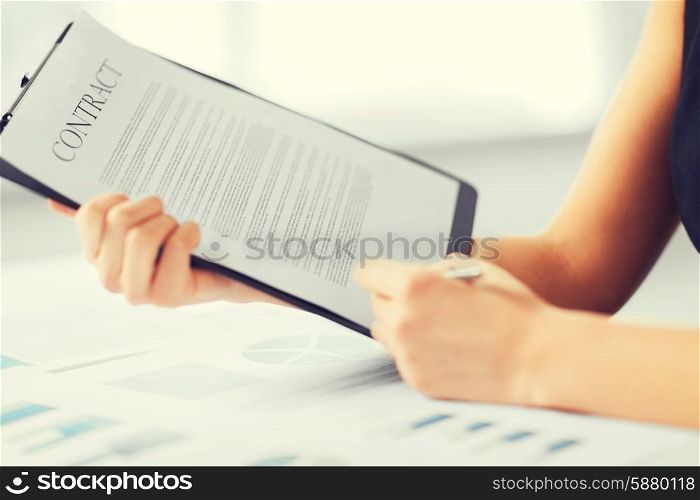 business, office, law and legal concept - picture of woman hand signing contract paper