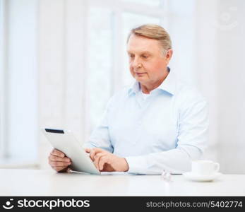 business, office, oldness, school and education concept - old man wearing eyeglasses with tablet pc computer at home