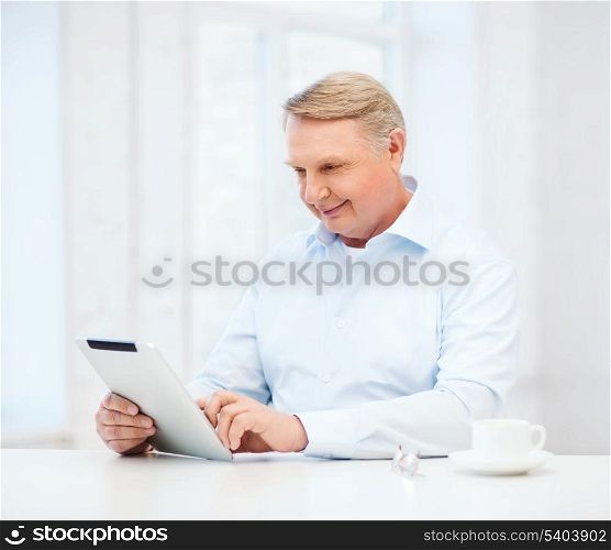 business, office, oldness, school and education concept - old man wearing eyeglasses with tablet pc computer at home
