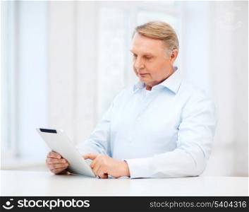 business, office, oldness, school and education concept - old man wearing eyeglasses with tablet computer at home