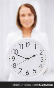 business, office, school and education concept - attractive businesswoman showing clock