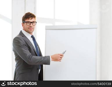 business, office, school and education concept - businessman pointing to flip board in office