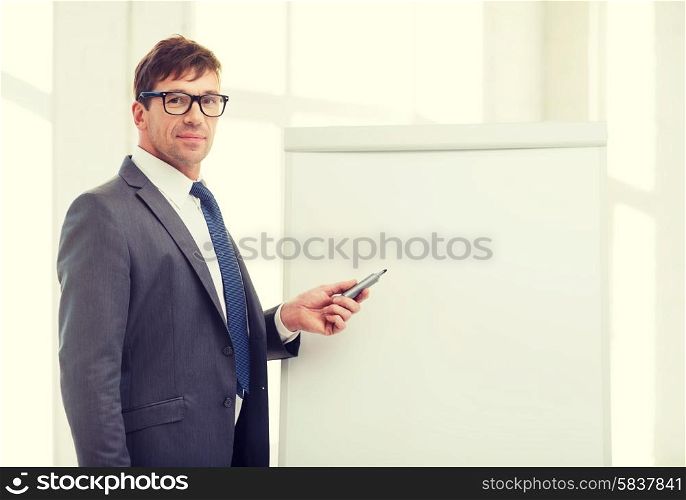 business, office, school and education concept - businessman pointing to flip board in office