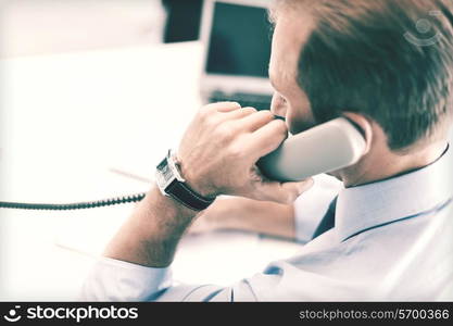 business, office, school and education concept - businessman talking on the phone