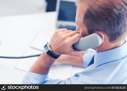 business, office, school and education concept - businessman talking on the phone