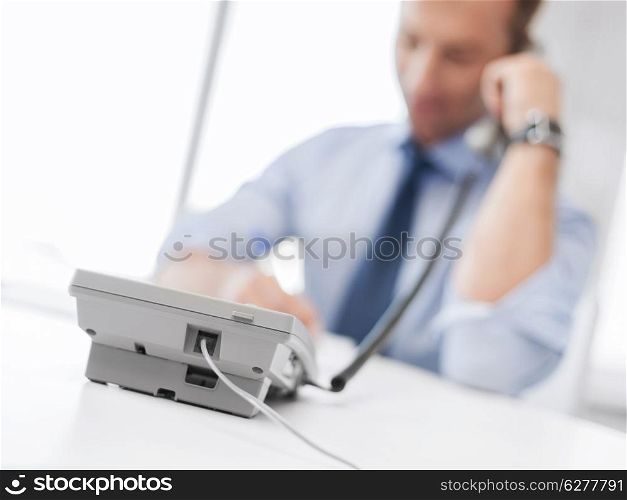 business, office, school and education concept - businessman talking on the phone