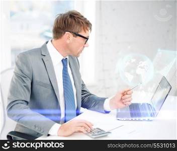 business, office, school and education concept - businessman with laptop computer, papers and calculator