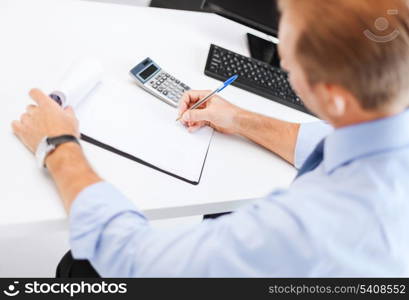 business, office, school and education concept - businessman with notebook and calculator